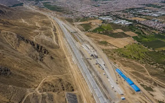Vista aérea de un corredor vial en construcción entre cerros y campos de cultivo