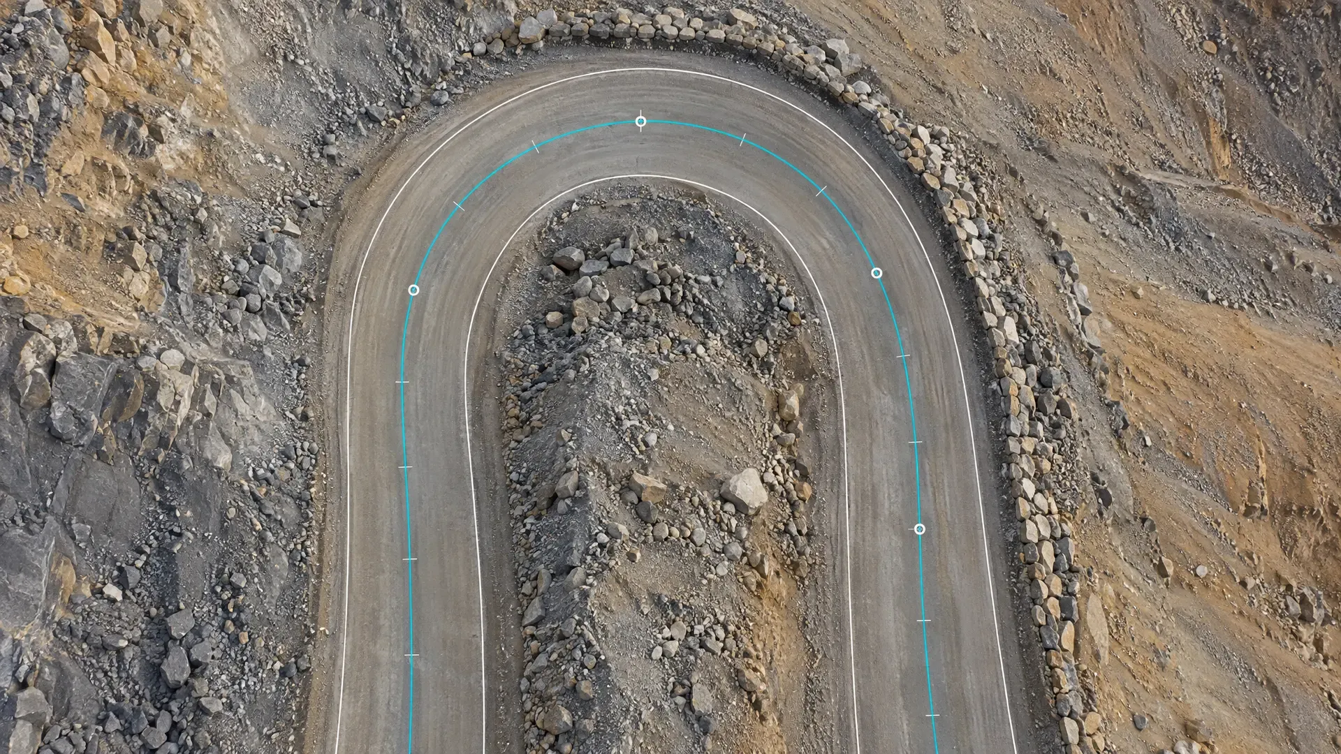 Vista cenital de un retorno en una vía de acarreo sobre un botadero, con los dos bordes de la vía trazados en blanco, un eje turquesa de rectas y arco con marcas de progresiva y cuatro puntos de paso