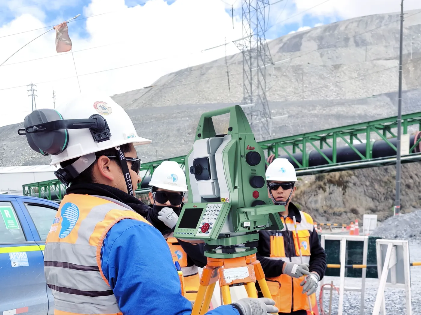 Cuadrilla de topografía operando una estación total Leica en una unidad minera