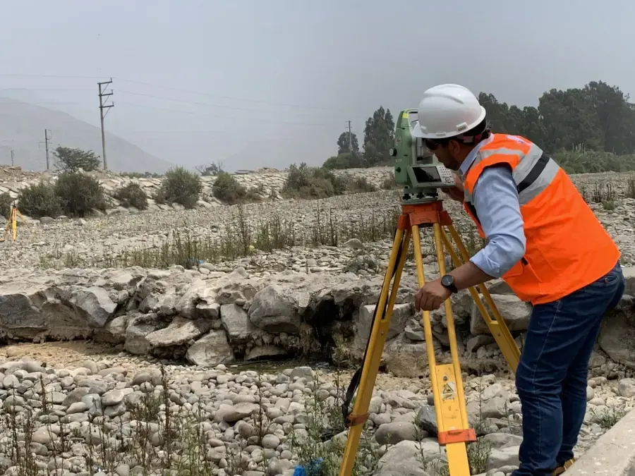 Estación total midiendo hacia prismas en una presa